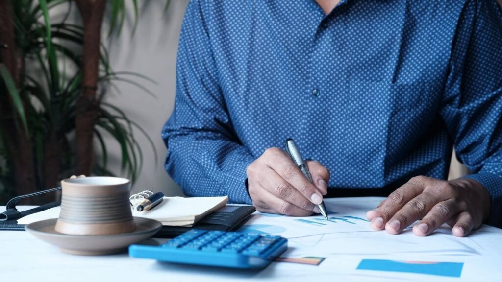Cloud Based Tax Software — using a calculator while reviewing paperwork